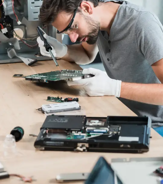 male-technician-repairing-computer-motherboard-wooden-desk